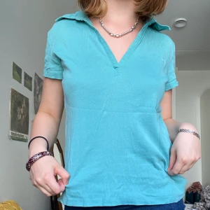 Turkos/Blå topp - Topp med otroligt Fin färg med krage och ett litet broderat märke. Frakt inkluderad!. Toppskick