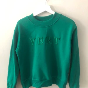 Grön college Tröja  - Jag säljer denna snygga gröna tröja med ett tryck på, VERT. Tröjan har  dragkedjor på varsin sida och den är inte mycket använd! Kontakta mig om du är intresserad, frakt ingår i priset