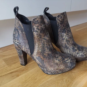 Ormskinn stövletter - Supersnygga "ormskinn" stövletter från exklusiva Rizzo. Nypris var 1495 kr. De har tyvärr aldrig kommit till användning så verkligen i nyskick! 