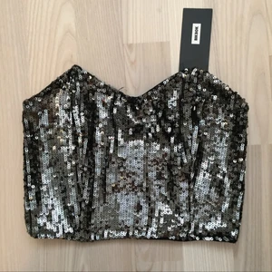  - Grå/svart paljett-topp från Bikbok. Oanvänd och i väldigt bra skick. Priset går att diskutera! Den är väldigt liten i storleken så skulle säga att det är XS. 