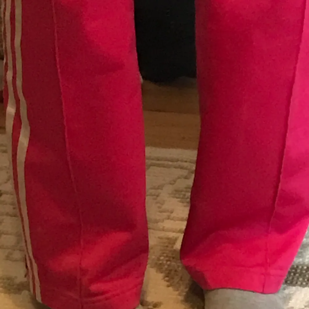Svincoola rosa Adidasbyxor som inte kommer till användning längre. Byxorna är lite smått slitna men det syns knappt.. Jeans & Byxor.