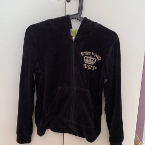 Juicy couture svart zip hoodie - Fint skick dock är J:et på dragkedjan åkt av, men dragkedjan funkar fortfarande utmärkt. Köpt för ca 1000kr. Säljer den billigt eftersom den använts mycket förr. Den är i storlek L (BARNSTORLEK, se bild 3) vilket passar mig som är ca 160 cm. Frakt ingår, skriv för intresse!