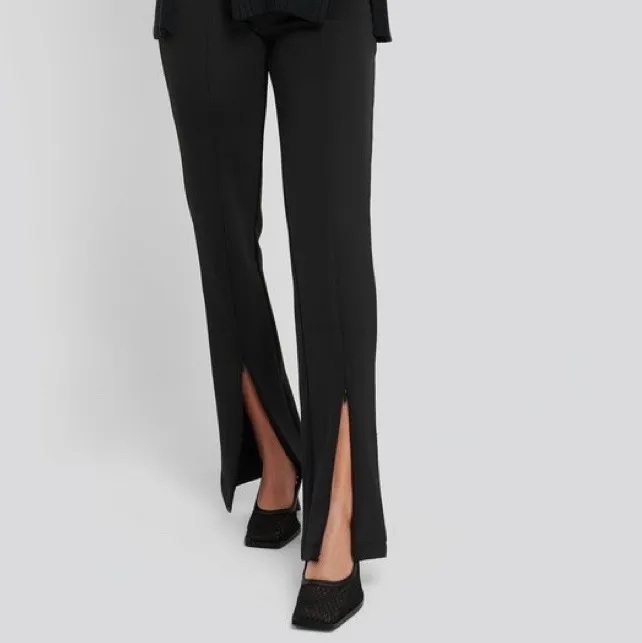 En par svarta kostymbyxor från NA-KD med slits där nere, säljer för 200kr. Storlek 44. (köparen står för frakt) säljer pga blivit för stora 🌸🌸. Jeans & Byxor.