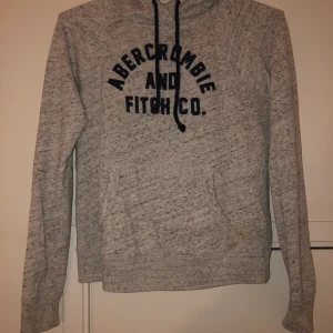 Abercombie hoodie - Hoodie från abebrcrombie and fitch. Grå med mörkblå text. Jättebra skick, mjuk och skön. Kan mötas i Stockholm eller frakta