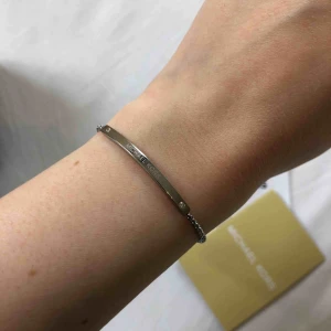  - Säljer Michael Kors armband i silver, jättefint, diskret och elegant. Självklart äkta. Inköpt för 895kr på Kronjuvelen i Norrköping. Kvitto finns. Frakt tillkommer