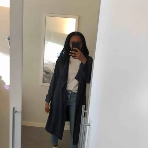  - Marinblå trenchcoat som är i storlek 42 med ger då en oversized effekt för mindre storlekar som jag har! Frakt tillkommer.