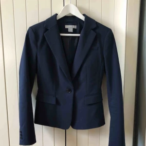  - Marinblå skräddad kavaj från H&M 1 knapp framtill 3 knappar på ärmslutet  2 fickor  Mycket fint skick!   Upphämtning centrala Uppsala  Vid frakt tillkommer porto på 72kr