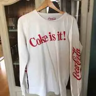 Coca-Cola tröja köpt på Pull&Bear. Röda Coca-Cola loggan finns på båda ärmarna, och texten ”Coke is  it!” på bröstet. Superskönt material och passform!! Relativt oversize fit. Köpare står för frakt! (:. Toppar.