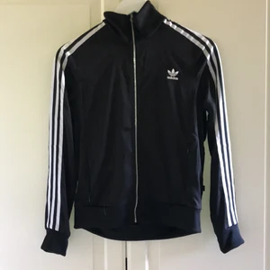 Adidas tröja  - Svart klassisk adidas tröja med räfflad rygg. Knappt använd. Säljer den pga att den inte riktigt är min stil. Strl 38. Frakten är inräknad i priset.