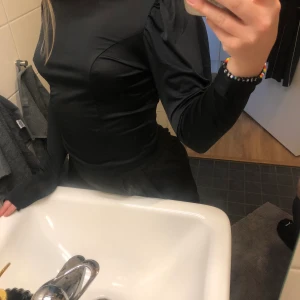 Svart tröja - Svart tröja i glansigt tyg med fina detaljer, köpt på bikbok för någon månad sen men aldrig använd. Tyget är relativt tunt och väldigt stretchigt, därför passar den även S. Frakten kostar 44kr🌻