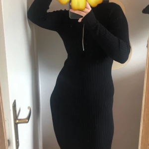 Tight svart klänning - Ribbad knälång klänning med hög krage och dragkedja som går att dra upp/ner för olika looks. Small men materialet är stretchigt och passar mig som är medium. Perfekt för fester och liknande! Använd kanske 5 gånger, om ens det. Köpare står för frakt :)