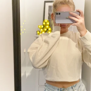 Sweatshirt Zara - Lite kroppad ljus beige sweatshirt från zara. Mjukt material använd ett få tal gånger. Köpt i vintras men fortfarande i bra sick då jag inte använt den sen våren. Lite kortare och bredare modell som passar perfekt till lite högre byxor. lite mindre i storlek då den är en kortare modell. Är i storlek M men passar även S och XS  (Jag är 165 lång och brukar ha storlek S såhör sitter den på mig)