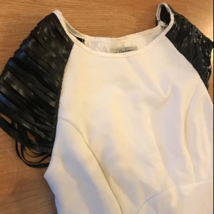  - Vit klänning med ”skinn”detaljer