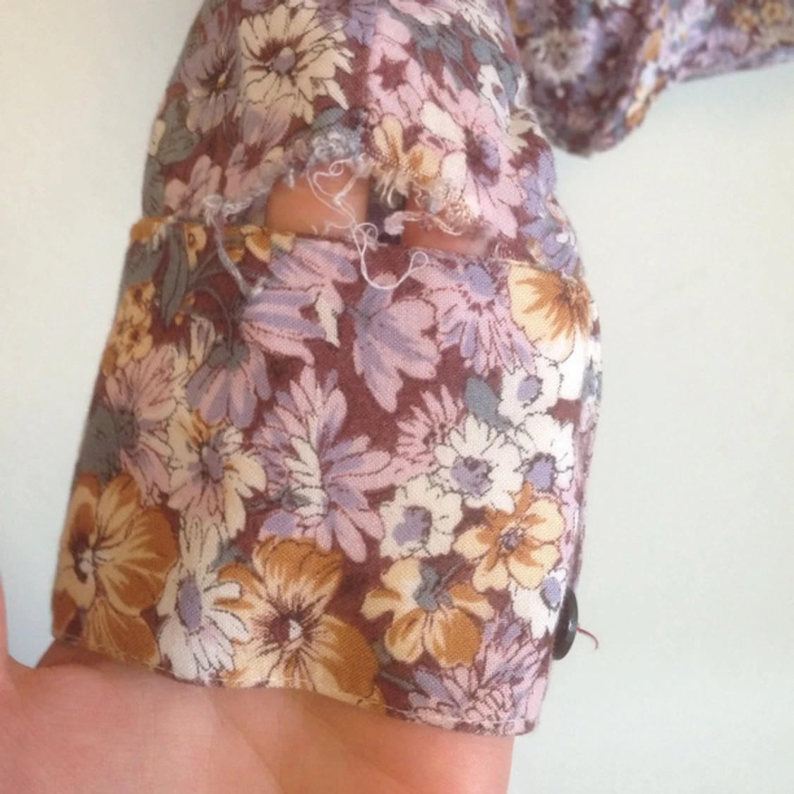 Ur fin blommig blus köpt secondhand. Ett litet hål som visas på bild 3. - 1393156288