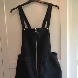  - Hängselklänning i lite mockaliknande tyg. Går att justera axelbanden på baksidan.
