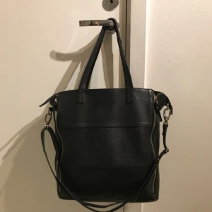  - Svart väska i läder från Wera. 38x36cm;Går att öppna dragkedjor på sidan så den blir ännu större. I gott skick! Skickas mot frakt eller upphämtning i Bergshamra.