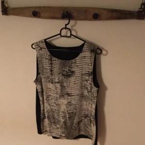  - Linne med snakeprint, omlott öppen rygg
St S 
Färg : Svart/vit
Märke: vila
Skick: sparsamt använd