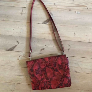  - Axelremsväska från monki i ormskinns imitation med justerbara axelband! Nyskick!  Köparen står för frakt 