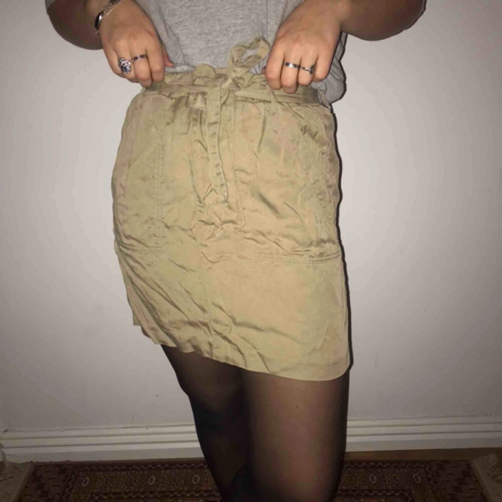 En kjol som inte gör sig rättvisa på bild. Men är militärgrön med ett knytbälte i midjan och fickor. Jättefint skick!💜🤠 Frakt: 80kr . Kjolar.