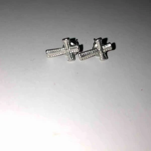  - Ett par korsörhängen. Nästintill oanvända. Köparen betalar frakten