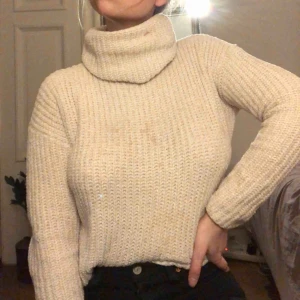  - Skön stickad tröja i skimrig krämvit. Med polokrage som man viker själv. Några fläckar men de går bort i tvätten innan de skickas. Köparen står för frakt:)