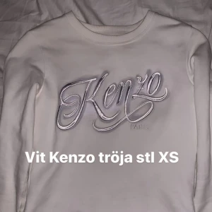 Vit kenzo tröja - Vit tröja från Kenzo med vit/silvrig logga. Storlek XS, väldigt lite använd så i fint skick, nypris runt 2000 kr. Högsta bud får den, börjar på 900 kr