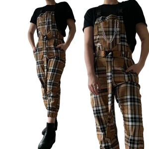 Hängslebyxor i Burberry mönster - Ett par ascoola hängslebyxor från Dollskill med kedjor och skärp som ingår i ett Burberry inspirerat mönster. Älskar dessa så men har knappt använts. Passar storlek XS-S. En snabb affär uppskattas 💜 