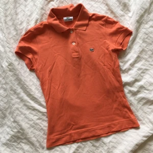  - Persikofärgad piké/t-shirt i strl 36 från Lacoste. Superfin på!! 