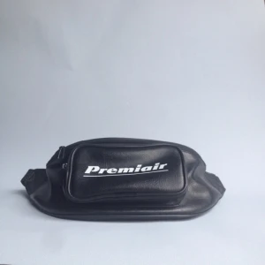  - Sidoväska/magväska med text Premiair. Bra skick. Bandet mäter ca 75 cm, med andra ord relativt kort.