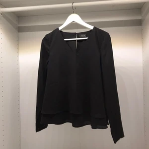  - Så snygg svart V-ringad blus i chiffong med volanger från VILA. Aldrig använd. Slutsåld! Passa på att fynda till ett lågt pris. 
