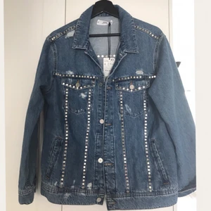  - Jeansjacka med platta silvernitar, inköpt på Mango för 700kr, aldrig använd med lappar kvar. Jeanstyget är mjukt så den är superskön att ha på sig! Storleken är One Size så det beror bara på vilken passform man föredrar.