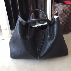  - I princip helt oanvänd handväska från H&M. Har ljusrosa/ljusbeige insida. Finns ett fack med dragkedja inuti där plånbok, nycklar, mobil etc får plats i. Annars försluts väskan med två "lädersnören" upptill. Frakt tillkommer