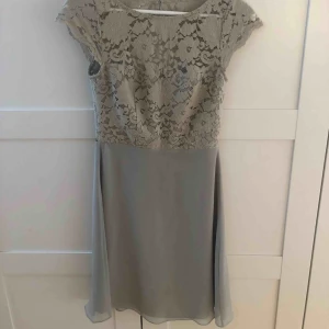  - Romantisk ljusgrön klänning ifrån designern Zetterberg. Använd en gång på bröllop, som ny. Tillhörande sidenband för användning runt midjan med knytning av rosett i ryggen, kan även bäras likväl utan! 