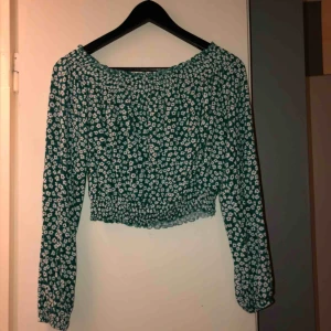  - Of shoulder top, croppad och i fint blommönster. Aldrig använd. Köparen står för frakten.