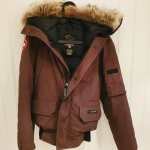  - Jacka från Canada Goose. Färgen är brungrön och det är äkta päls. Jättefint skick. Passar den som har storlek XS eller S. 