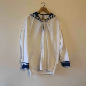  - Vintage sjömansskjorta. Sitter som medium / liten large i herrstorlek. Några ljusa fläckar som inte försvann i tvätt, går säkert bort vid kemtvätt/ bättre behandling. Uppskattningsvis från 70-talet. Du kan inte gå på Håkan utan denna. 