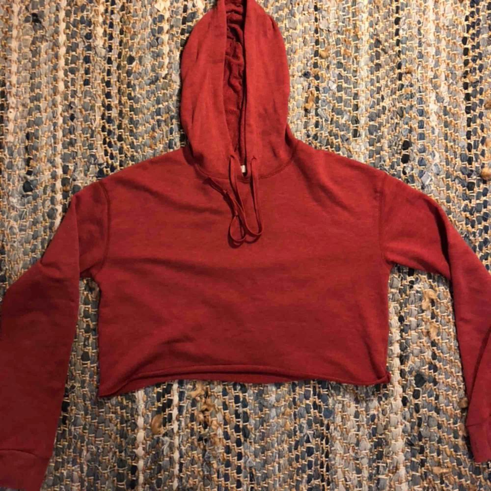 Croppad röd hoodie köpt från Urban outfitters. Använd fåtal ggr och är i nyskick.. Huvtröjor & Träningströjor.