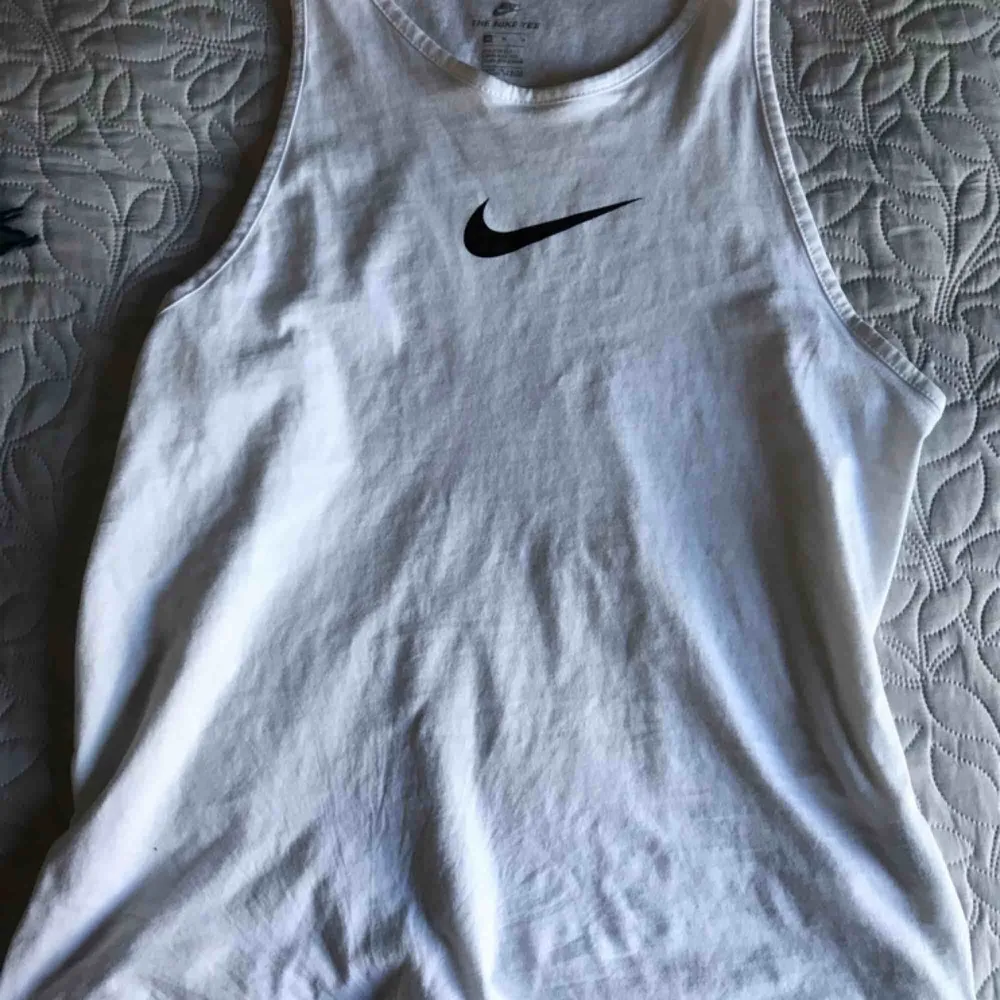 Snyggt basic vitt linne från Nike. Svart logga. Strl M, jättefint skick!  Frakt betalas av köpare om det ska skickas!🌸. Toppar.