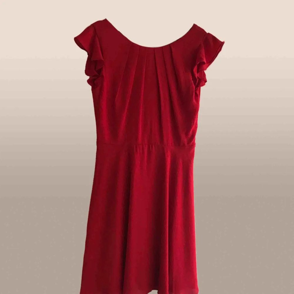 Röd klänning med djup urringning i ryggen. Väldigt klarröd i färgen. . Klänningar.