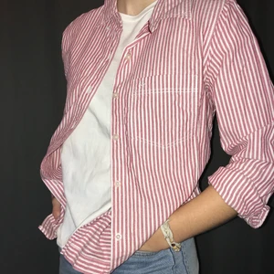 Röd/vit-randig skjorta - Röd/vit-randig skjorta, strl M men passar även XS/S beroende på önskad passform. Köpare står för frakt