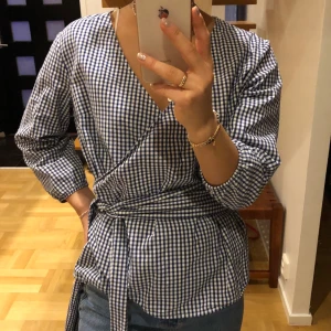 Blus - Härlig wrapped blus med band i midjan som går att knyta på olika sätt alternativt ta bort. Sitter bra på mig som är S så funkar nog om man är XS-M ungefär