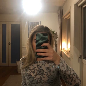 Mesh topp med Blommigt mönster  - Blommig meshtopp i bra kvalite! Väldigt skön och stretchig i storlek M men sitter bra på mig som är XS. 