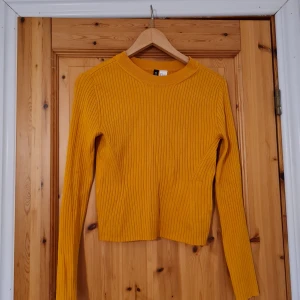 Gul långärmad tröja - Senapsgul tröja i "randigt" material. Färgen matchar första och sista bilden, ej andra. Från H&M, storlek S, använd ett fåtal gånger.