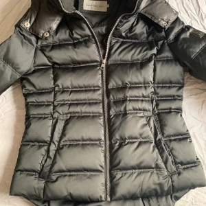 Calvin Klein dunjacka - Calvin Klein dunjacka, 2 år gammal, väldigt sparsamt använd. Nypris 3995kr. Mitt pris 600kr, kan tänka mig billigare vid snabb affär. Kan skickas om köparen står för frakten.