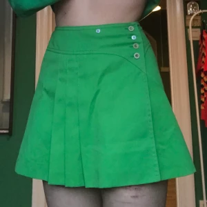 Vintage tennis kjol - Super snygg grön tennis kjol i typ storlek S-M. När den köptes så fattades knappar så fick laga den med dom jag hade hemma, det är därför det är olika knappar. Helt oanvänd o köparen står för frakten 💕