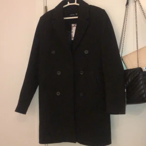 Oversized kappa - Helt oanvänd oversized kappa med knappdetaljer från Boohoo. Storlek 38 men passar även 40-42 då den är lite stor i storleken. Varm och lång, perfekt för hösten! 