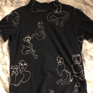 Kortärmad polotröja - Marinblå kortärmad polotröja med vita figurer i strl XS. Skriv om du vill ha bättre bilder på plagget, tex passform på kroppen osv!