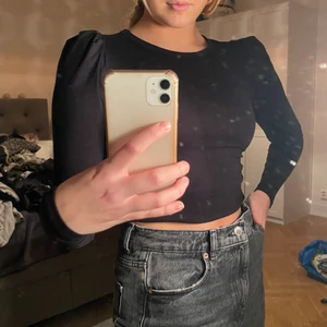 Långärmad svart top med puffiga armar - Säljer denna snygga top från Gina med puffiga armar i storlek S. Passar XS-M. Nästan oanvänd.