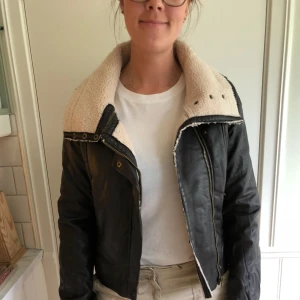  - En fejkskinnjacka i bikermodell med foder inuti. Endast använd ett fåtal gånger, bra skick. Jackan kommer från Carlings och färgen är mörkbrun.