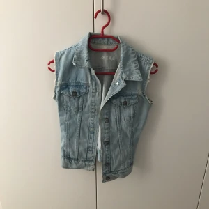  - En jeansväst köpt för längesen, minns ej vart. Sitter ganska nära inpå kroppen så passar nog bäst till S eller mindre än S!  Lätt och matcha med andra plagg, t.ex klänningar m.m.  Använd ett fåtal gånger, i nyskick! 